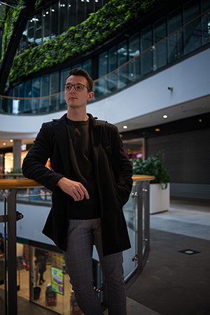 A well dressed young sitting in a shopping mall.