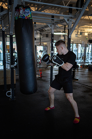 A young man practicing boxing in the gym.