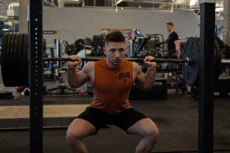 Portrait of a young man practicing weight lifting in the gym.