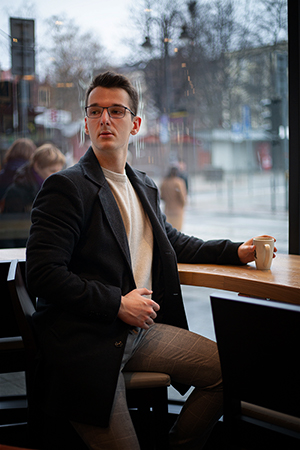 A young man in a cafe, a cloudy autumn day.