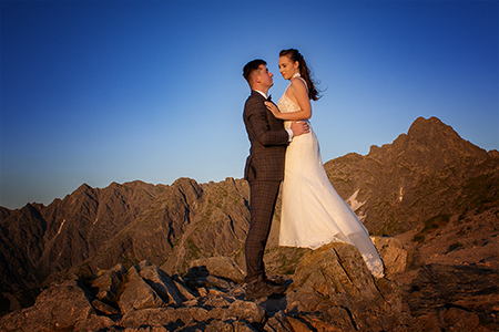 Bride and groom huging in a rocky mountainside.