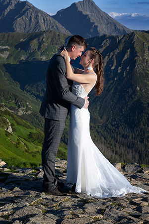 Groom and bride are huging at Tatra mountains.