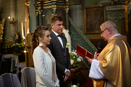 Couple is getting married at the church. They both look the priest as he read Evangelion.