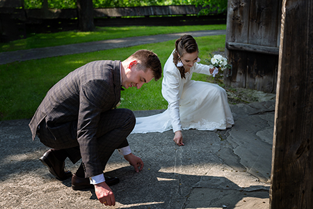 Bride and groom after the wedding, collecting coins outside the church in a green yard. This is an old Polish wedding tradition.