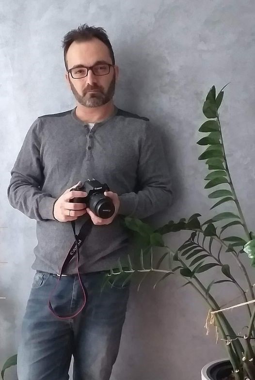 Photographer Simos Ksenos holding a camera.